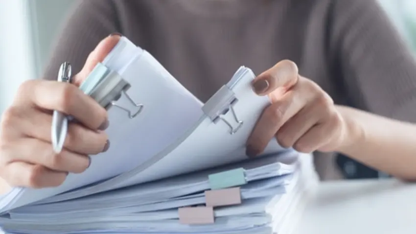 Businesswoman hands working with stack of paper document 