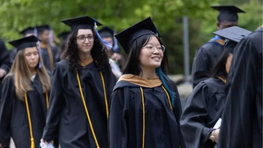 Bentley Class of 2026 graduates process into the Bentley Arena for McCallum Graduate School commencement