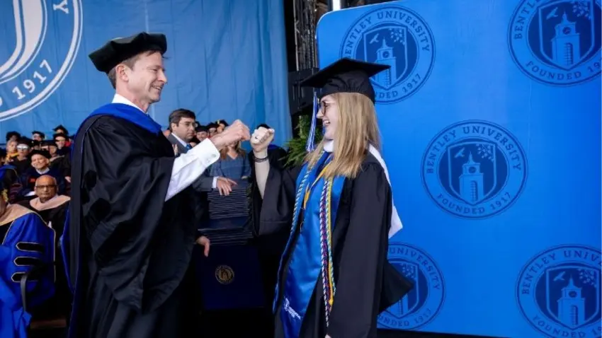 Bentley provost fist pumps his daughter, a Class of 2026 graduate, on stage at commencement