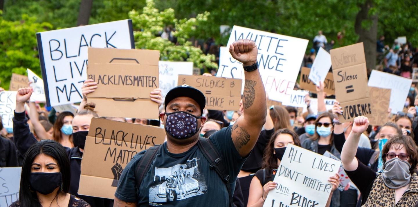 Black protestors in a march with signs