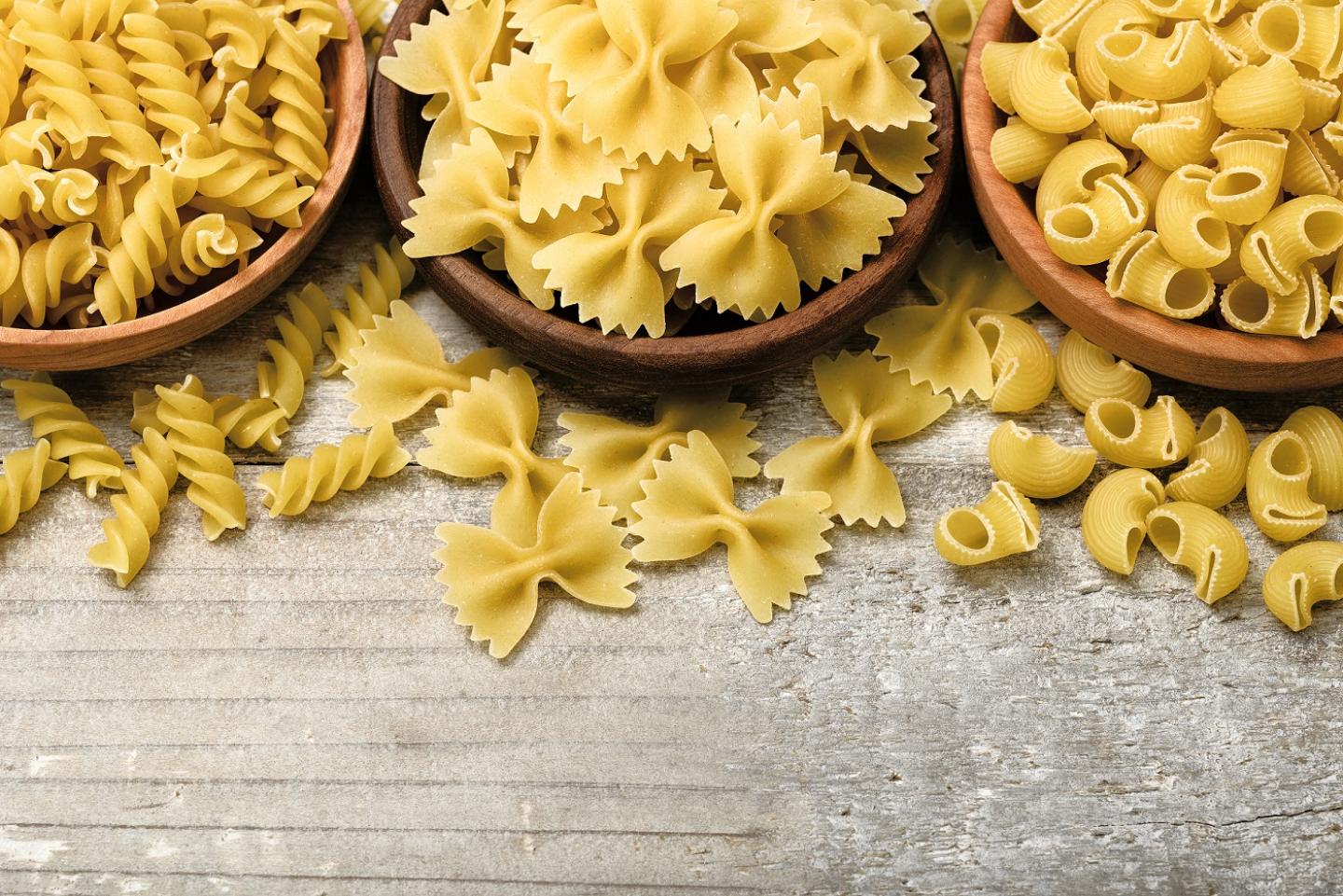 Bowls of rotini, farfalle and pippete dry pastas.