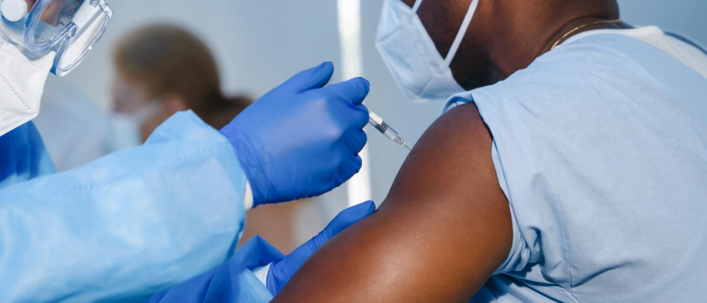 Person receiving a COVID-19 vaccination shot in the arm