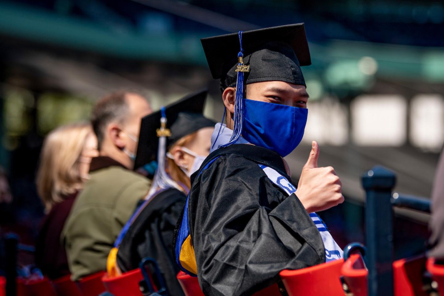 Student gives a thumbs up at the Bentley Commencement at Fenway Park 2021