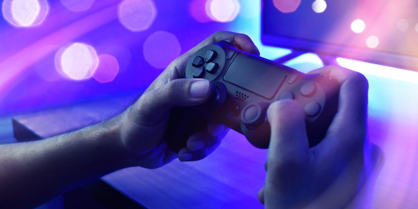 Photo illustration of a person's hands holding video game controller