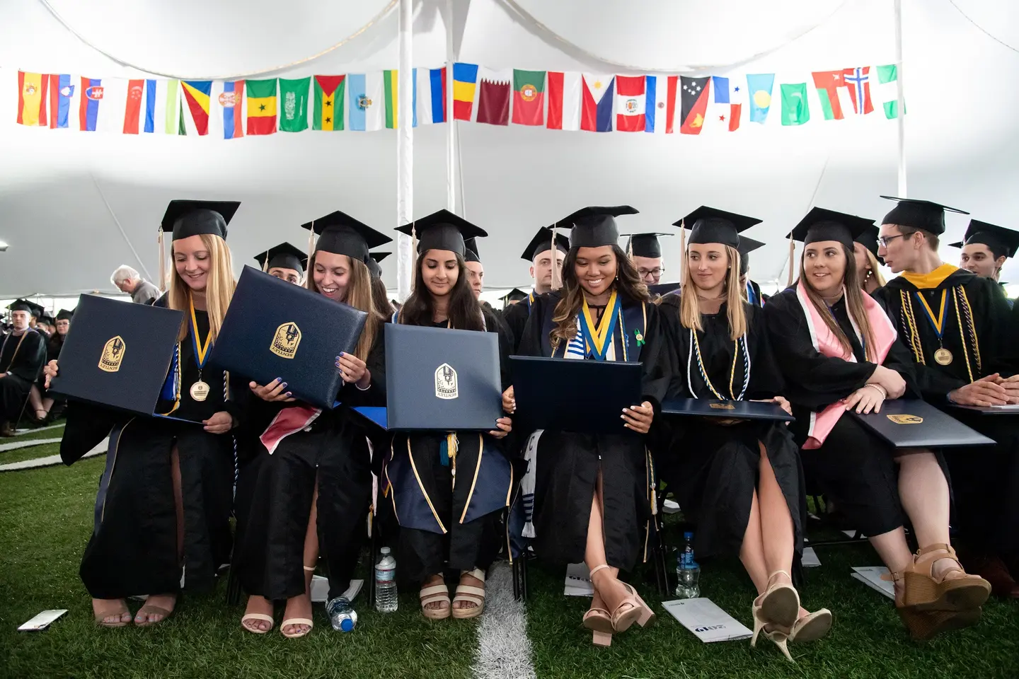 Students celebrate in caps and gowns after receiving their diplomas