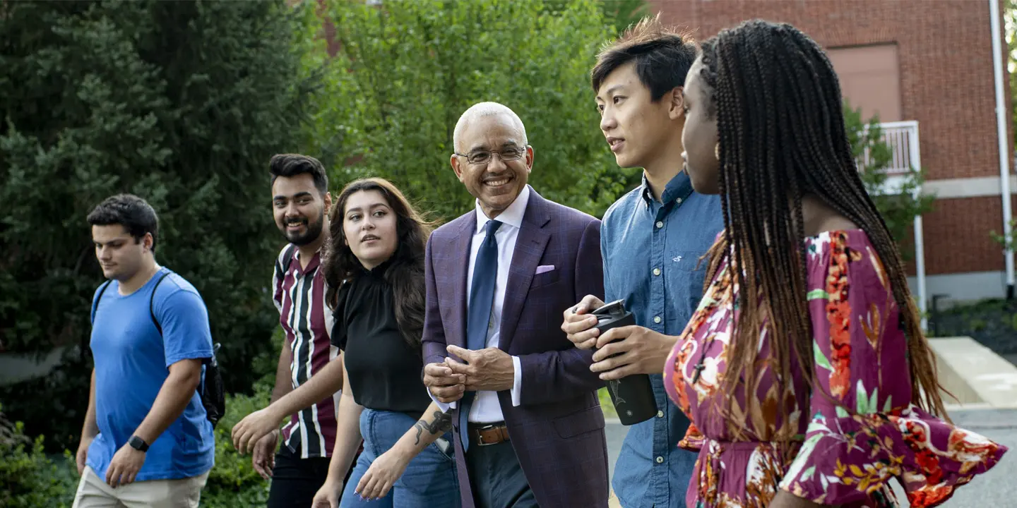 Bentley President Chrite and students walk on campus