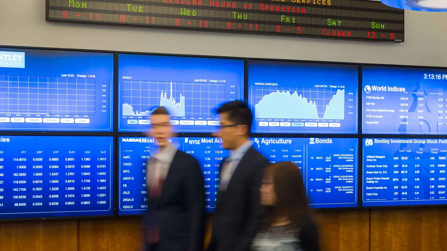 two men walking by trading room screens