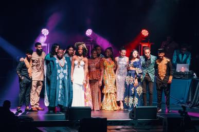 Bentley students and gala attendees on stage dressed in traditional African clothing 