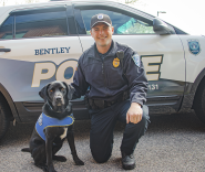 Sergeant Bartkus and Blue the Comfort Dog pose in front of their car